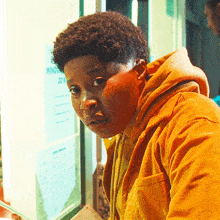 a man in a yellow jacket looks at a sign that says wing