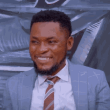 a man in a suit and tie is smiling and looking at the camera