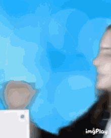 a blurry picture of a woman 's face with a blue background and the words imgplay on the bottom