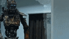 a robot is standing in a room with a broken glass door .