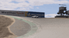 a car is driving down a race track with a sign that says weather tech on it