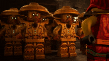 a group of lego figures are standing next to each other with one wearing a red outfit
