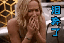 a woman is covering her mouth with her hands and there is chinese writing on the bottom of the image .