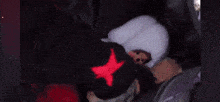 a dog is sleeping in a stroller next to a stuffed animal and a person wearing a mickey mouse hat .