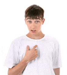 a young man in a white t-shirt is pointing to his chest