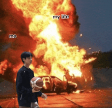 a man holding a basketball stands in front of a car on fire