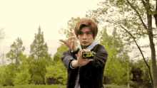 a young man is holding a camera in his hand and making a gesture