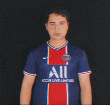 a man wearing a blue and red shirt with the word all on it is giving a thumbs up .