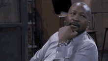 a man wearing a watch and a tie is thinking