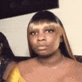 a woman in a yellow dress is making a funny face .