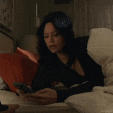 a woman laying on a bed looking at her phone with the hashtag ritualyas visible