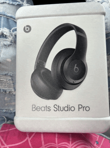 a box for beats studio pro headphones sits on a pink blanket