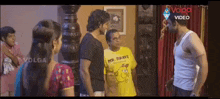 a man in a yellow shirt that says mr. brave is talking to a group of people