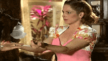 a woman in a pink dress is talking to someone