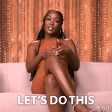 a woman is sitting on a couch with her legs crossed and says let 's do this