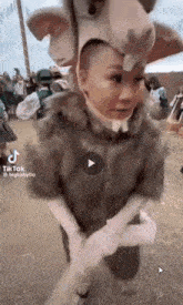 a woman in a rabbit costume is standing in front of a crowd of people .