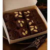 a box of chocolate brownies and cupcakes with almonds on top