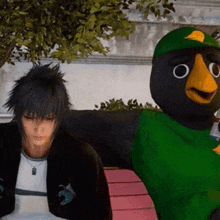 a man sitting next to a stuffed bird with a green shirt on