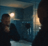 a man with a beard is brushing his teeth in front of a bathroom mirror