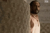 two men are walking down a hallway with a follow us x on the bottom right