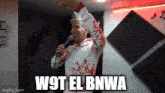 a man singing into a microphone with the words w9t el bnwa written above him