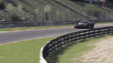 a race car is driving down a track with a fence in the background
