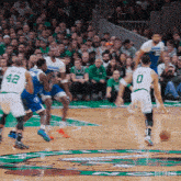 a basketball game is being played in front of a crowd and the number 0 is on the player 's jersey