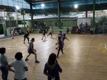a group of people are playing a game of basketball on a wooden court