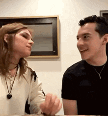 a man and a woman are looking at each other and smiling .