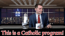 a man in a suit and tie is sitting in front of a microphone with the words this is a catholic program