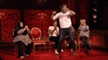 a group of people are sitting in chairs and a man is dancing in front of them with the words in your written on the bottom