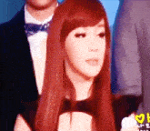 a woman with red hair is standing next to a man in a suit and bow tie