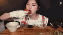a woman wearing gloves is eating a piece of pizza