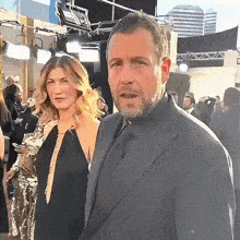 a man and a woman are standing next to each other on a red carpet