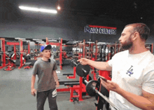 a man in a zoo culture shirt points at something
