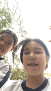 two girls are posing for a picture and one has braces