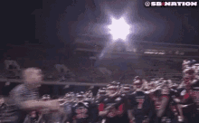 a group of football players are standing in a stadium .
