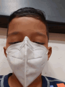 a young boy wearing a white face mask with the letter n on it