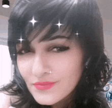 a close up of a woman 's face with sparkles on her forehead