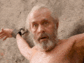 a shirtless man with a beard and chains around his neck