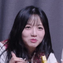 a close up of a woman eating a piece of food with a fork