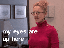 a woman wearing glasses and a pink turtleneck says my eyes are up here