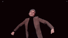 a man in a brown suit and black turtleneck is dancing on a stage in a dark room .