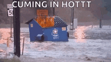 a dumpster is on fire in a flooded area and says cumming in hottt on the bottom