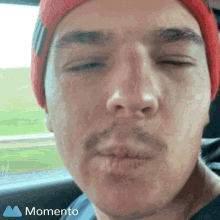 a close up of a man 's face with the momento logo on the bottom right