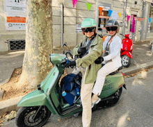 a man and a woman are riding a green scooter that says ' ii ' on the front