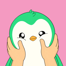 a green and white penguin with a yellow beak is being held by two hands on a pink background