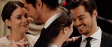 a man in a suit and tie is kissing a woman on the cheek
