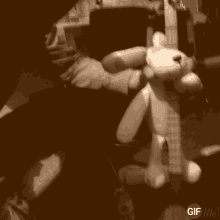 a person is holding a stuffed animal while playing a guitar with a gif me watermark