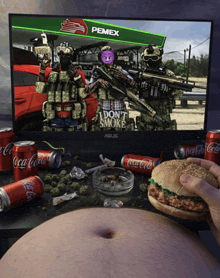 a person is eating a hamburger in front of a pemex sign